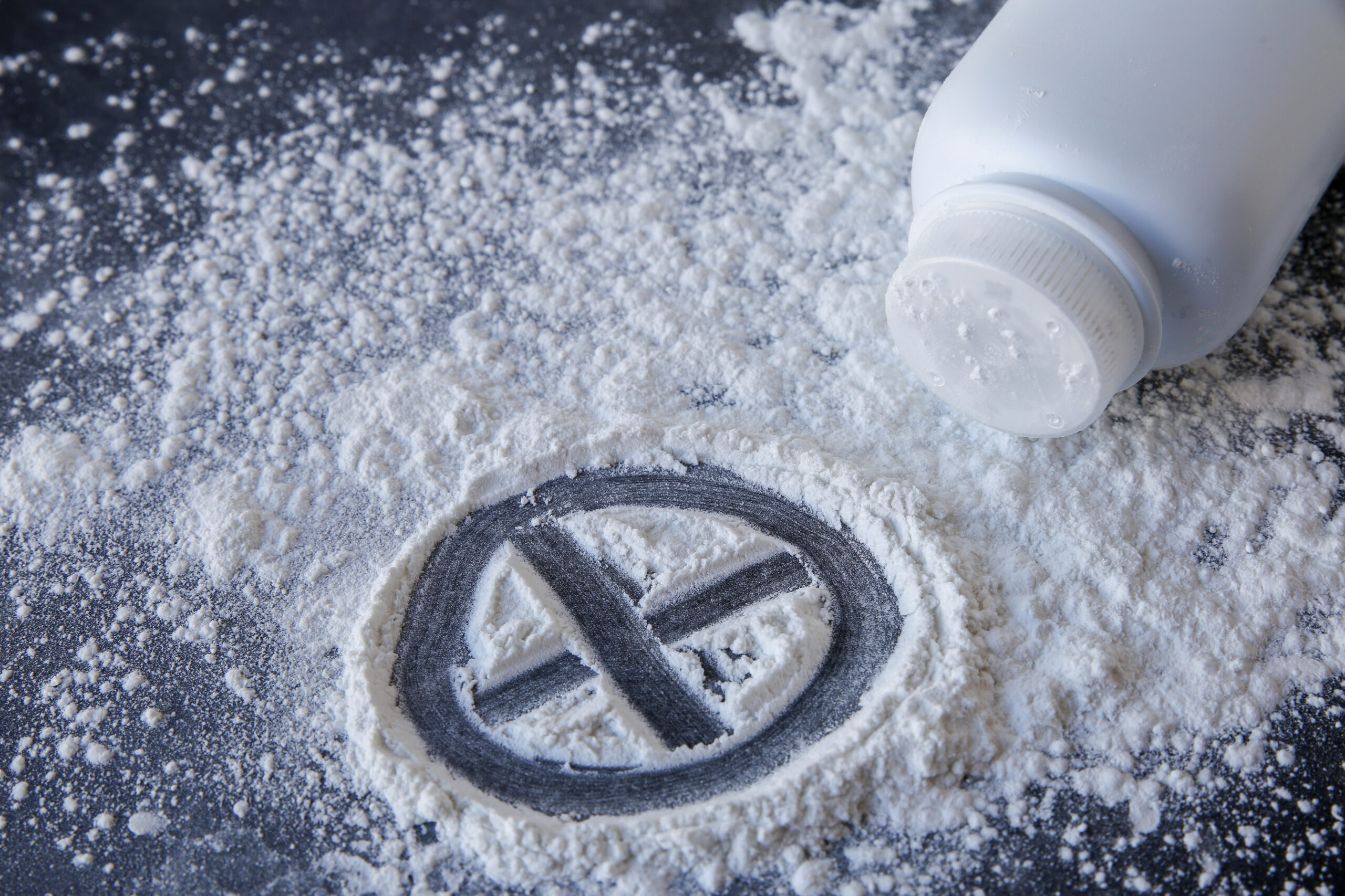 Talcum powder with cross sign on black background